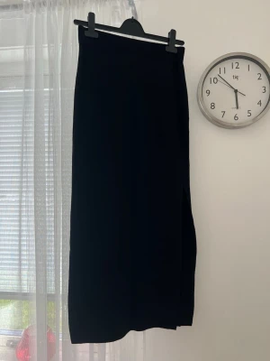 Stickad svart kjol, storlek M - Säljer en svart stickad kjol med slits längst vänster ben. Väldigt stretchig i materialet.   Köptes för ett par år sedan, aldrig använd. True to size.