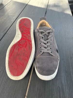 Louboutin - Använda louboutins med ett litet brännmärke på sidan av vänsterskon. Annars är skorna i topp kvalite. Kommer i färgen grå och röd sula. Intressad? Skicka ett bud!