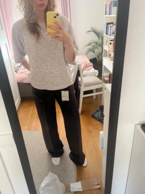 Svarta kostymbyxor med raka ben - Säljer ett par svarta mjukisbyxor med rak och lite vidare passform. Byxorna har resår i midjan och är gjorda i ett mjukt, bekvämt material som är perfekt för chill dagar. Enkla att matcha och riktigt sköna att ha på sig. Passar även om man vanligtvis har någon mindre storlek