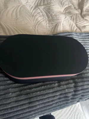 Dyson hårstyler med tillbehör - Kontakta mig för mer info🤍 Säljer en Dyson hårstyler i elegant svart och rosa förvaringsbox. Medföljer rundborste med svarta borst och flera stylingtillbehör. Perfekt för dig som vill fixa håret snabbt och smidigt med högteknologiska verktyg. Priset kan givetvis diskuteras💕 Nypris 5000-7000kr