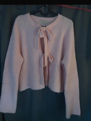 Stickad tröja med rosetter  - Rosa stickad tröja från gina tricot med knutna rosetteri storlek XS men funkar jätte bra för S också. Jätte fin nu till hösten🍂 💕. Säljer för att den inte kommer till användning. Köpt för ungefär 400kr.