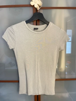 Ljusgrön basic t-shirt Gina Tricot - En enkel och stilren ljusgrön t-shirt från Gina Tricot i storlek XS. T-shirten har rund halsringning, korta ärmar och är gjord i ett mjukt och stretchigt material som sitter snyggt på kroppen. Perfekt att matcha med jeans eller kjol.