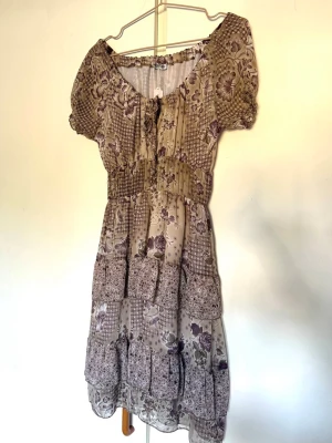 Vintage blommig klänning  - Jättefin och söt klänning! Kan bäras vanligt eller off-shoulder. Made in Italy. Köpt secondhand i Stockholm, prislapp kvar. Väldigt bra skick! Har en underkjol så den är inte genomskinlig, något genomskinlig vid bröst men väldigt lite. 