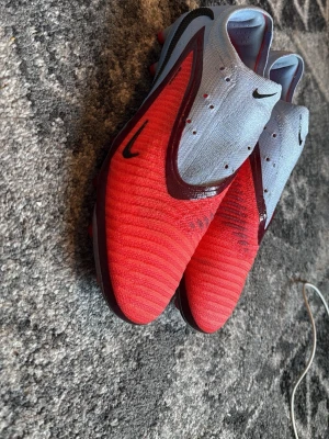 Nike Phantom röd/grå fotbollsskor - nike phantom elites, snören är tyvärr försvunna men påsen har kvar, eftersom snören är försvunna så sänker jag priser