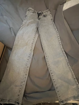 Gråa vida jeans med hög midja - Säljer ett par gråa jeans med hög midja, knappt använda från madlady! 
