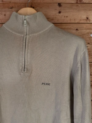 Peak Performance vintage quarter zip sweater Made in Italy XL - Vintage Peak Performance quarter-zip i beige/sand. Modell Colbin, Made in Italy, med hög ribbad krage och diskret broderad Peak-logga på bröstet. Troligen sent 90-tal/tidigt 00-tal.  Storlek XL. Bra vintageskick med normala bruksspår.  Mått: armhåla–armhåla 57 cm, axlar 47 cm, ärm 60 cm, längd 64 cm.