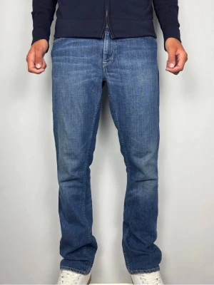 Ralph Lauren Blue Label Authentic Denim jeans  - Ralph Lauren Blue Label Authentic Denim jeans med läderpatch bak och riktigt fin rak passform.  Färg: Blå Passform: Straight Storlek: W32 L32 Mått [platt] (±1 cm): A: 44,5 cm B: 103 cm D: 21 cm