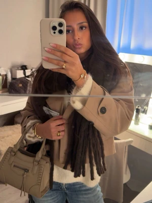 Mörkbeige ZARA trenchcoat - Mörkbeige trenchcoat med stora svarta knappar och givetvis fickor vid sidan som är lite diskreta och inte sticker ut direkt. Jätte trevlig till hösten 🍁🕯️🤗🤗