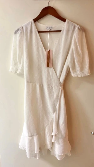 Vit omlottklänning - Söt vit omlottklänning, helt oanvänd 💕Passar perfekt till finare tillfällen, som midsommar eller student. Prislapp är kvar, storlek M, orgpris 540:- 🌸