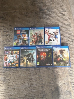 7 PS4-spel: action, äventyr & sport - 250kr styck, Samling med sju PlayStation 4-spel: LEGO Jurassic World, Assassin's Creed IV Black Flag, EA Sports UFC, Grand Theft Auto V Premium Edition, Titanfall 2, Minecraft och ARK Survival Evolved. Alla spel i blå plastfodral med färgglada omslag. Perfekt för dig som gillar action, äventyr och sport.