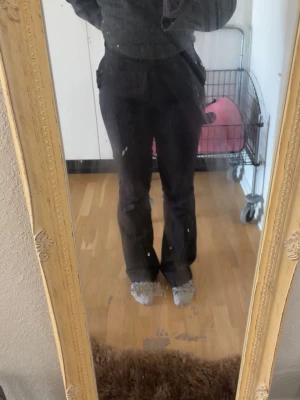 Svarta kostymbyxor med fickor - Säljer ett par svarta kostymbyxor med raka ben och diskreta fickor bak. Byxorna har en klassisk passform och är perfekta för en stilren look. Materialet är slätt och ger en dressad känsla. Passar dig som vill ha en enkel men snygg byxa. Dragkedjan är sönder o behöver bytas men kan fixas hos sömmerska snabbt för ca 150kr 