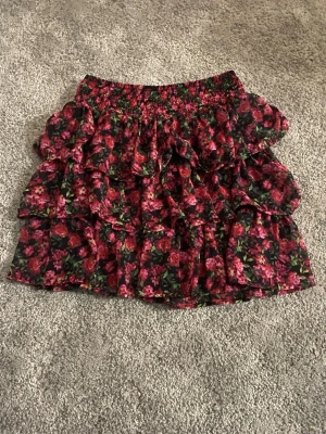 Blommig volangkjol från Lindex - Blommig kjol från Lindex i storlek 158/164 som motsvarar ungefär S. Knappast använd så den är som ny💕