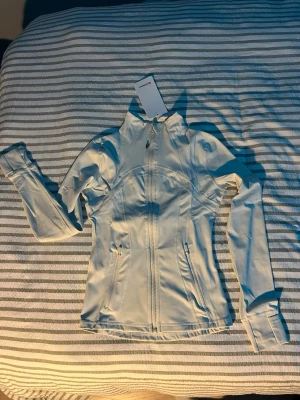 Lululemon jacka vit - Helt ny jätte fin vit lululemon jacka i amerikansk storlek 4, storlek XS/32. Längden finns på 4e bilden.
