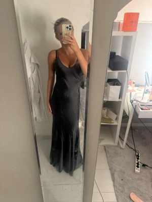 Mörkgrå silkes långklänning  - Säljer en mörkgrå långklänning i silkes matrial från zara, perfekt för t.ex. bal, fest och andra saker. Den är i storlek xs och har en jättefin passform och perfekt längd.