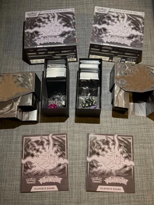 Pokémon Mega Evolution Pitch Black Elite Trainer Box - Detta paket innehåller två Elite Trainer Boxar från Pokémon Mega Evolution Pitch Black-serien. Medföljer gör även två spelarguider, två tärningsset och två kortfack. Har öppnat de och sleevat alla ex och Reverse holos och holos. Vid snabbaffär kan jag diskutera priset. Säljes för 2500 tillsammans man kan köpa separat också ena för 1100kr och andra för 1400kr.