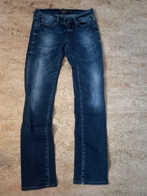 Mörkblå replays - Snygga mörkblå jeans med slim fit passform och lätt slitna detaljer framtill. Klassisk femficksmodell med dragkedja och knapp. Jeansen har en något stretchig känsla och raka ben. Perfekta för en trendig och avslappnad look.