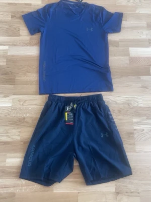 Blått träningsset från Under Armour - T-shirt i M och shorts i M. Helt ny