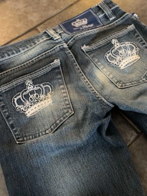 Lowwaist flare Victoria Beckham jeans - Snygga blå jeans med slitningar och unika vita kronbroderier på båda bakfickorna. Klassisk femficksmodell med dragkedja och knapp. Priset kan såklart diskuteras💗💗
