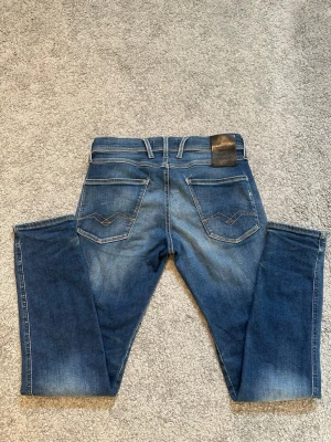 Blå slim fit jeans med tvättade detaljer - Snygga blå slim fit jeans med tvättade detaljer och klassiska fem fickor. Jeansen har ljusare partier på lår och knän samt dekorativa sömmar på bakfickorna. Tillverkade i ett mjukt denimtyg med stretch för extra komfort.