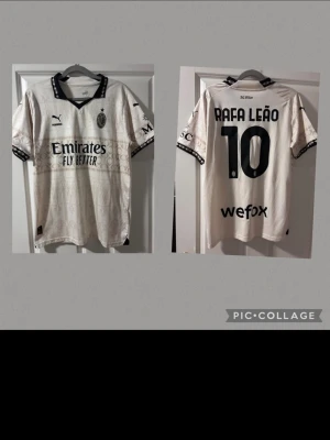 AC Milan bortatröja Rafa Leão #10 - Säljer en vit AC Milan bortatröja från Puma med svarta detaljer och tryck. Tröjan har Rafa Leão och nummer 10 på ryggen, samt sponsorer som Emirates och wefox. Klassisk V-ringning och mönstrade detaljer på tyget. Perfekt för fotbollsfans!