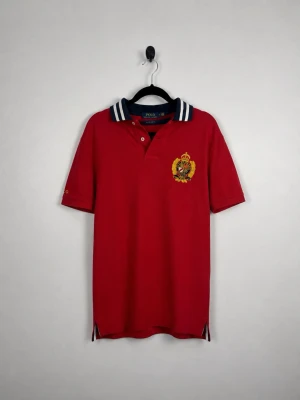 Vintage Polo Ralph Lauren Custom Slim Fit Crest Piké S Röd Navy Vit Polo Shirt - • Storlek: S • Färg: Röd  • Passform: Custom Slim Fit  • Krage: Randig ribbstickad pikékrage • Material: 100% bomull  Skick: Plagget är i väldigt fint skick. Eventuella anmärkningar anges alltid tydligt i beskrivningen och visas på bilderna.  Nypris: Cirka 1 400 kr.  📦 Skickas snabbt och packas omsorgsfullt. 💬 Hör gärna av dig om du har frågor eller vill se fler bilder. 🤝 Samfrakt erbjuds vid köp av flera plagg – kika gärna in mina andra annonser!