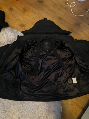 Canada goose wyndham black badge - Säljer denna feta svarta canada goose wyndham med black badge, använd knappast, med NFC, varma fickor, luva som går att tillsätta päls på och ta av generellt, alla taggar ingår.