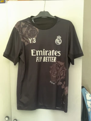 Real Madrid Tröja - Säljer denna feta Real Madrid då den ej passar mig. Tröjan är i 7/10 skick. Aldrig använd men dock har den en liten skada vid märket som går säkert att fixa till. Tröjan är i storlek L men kan passa dig som bär storlek M. Om du är intresserad eller har frågor så är det bara att höra av dig🤝