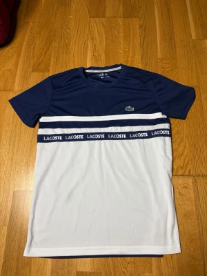 Blåvit Lacoste t-shirt  - Extremt snygg oanvänd Lacoste T-shirt i storlek S