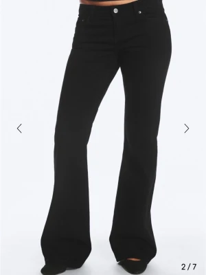 Weekday low waist svarta nova  - Modell Nova. 30/34. Snygga svarta bootcut jeans med hög midja och klassisk femficksdesign. Jeansen har utsvängda ben och bälteshällor i midjan. Perfekta för dig som gillar en tidlös och trendig look. Materialet ser ut att vara stretchig denim för extra komfort.