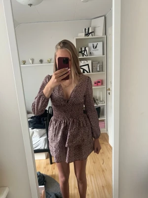 Blommig kort klänning med v-ringning - Söt kort klänning med småblommigt mönster ! Den sitter MYCKET bättre på nån som är S/XS. Köp gärna ! Vet ej var den ifrån för jag köpte den p vinted för 450kr ❤️
