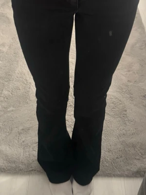 Svarta bootcut jeans Nelly - Säljer svarta low waist jeans från Nelly i storlek 34 (xs). Urtvättad svart färg annars fint skick.                   Ord. pris 699kr.  Kontakta vid frågor och vid intresse! 
