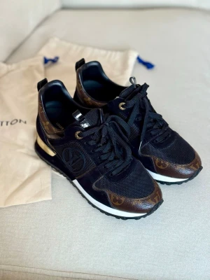 Louis Vuitton svarta sneakers - Fina Louis Vuitton Run Away Trainers i färgen svart/brun.  Storlek 35,5 Skick: som nya.  Inköpta i butik i Stockholm 2021 med Date-code inuti.  Säljs med dustbags till vardera sko.  Pris kan diskuteras vid smidig affär.