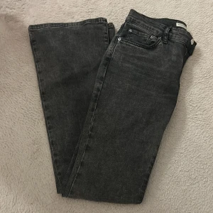Svarta Low waist bootcut jeans från Gina  - Snygga svarta jeans från Gina med bootcut passform och klassisk femficksdesign. Jeansen har en mörk tvätt och är tillverkade i slitstarkt denim. Perfekta för dig som gillar en clean och stilren look. 