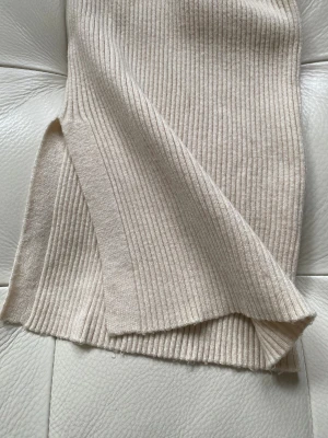 Beige ribbade mysbyxor från Pernilla Wahlgrens design - Snygg beige ribbade mysbyxor från Pernilla Wahlgren Design i storlek L. Byxorna har en mjuk stickad känsla, snörning i midjan, bred resår och en liten guldfärgad detalj med ananas. Perfekt för dig som gillar stilrena och bekväma plagg med twist. Byxorna är aldrig använda. Säljes pga felköp.