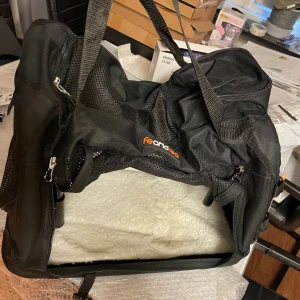 Svart djurväska från Feandrea - Säljer en svart djurväska från Feandrea med meshpaneler och flera dragkedjor. Väskan har justerbara axelremmar, praktiska fack och är tillverkad i slitstark polyester. Perfekt för att bära med sig mindre husdjur eller grejer. Har även säkertsbälten för extra trygghet. Hör gärna av er vid frågor. . Pris kan även diskuteras vid snabb affär 