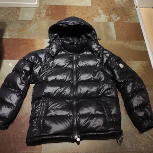 Svart Moncler Maya - Säljer en äkta svart Moncler Maya i bra skick. Inga skador eller defekter, enda ar att lite styng på armen har åkt upp men det ar inget man själv märker vid användning! Jackan innehäller Scan både på insidan av jackan (bild ovanför) samt på jackärmen. Priset är ej hugget i sten! Alltid öppen för frågor och förhandlingar! Storlek 3 som motsvarar M/L