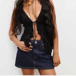 Mörkblå jeanskjol från Stradivarius - Snygg mörkblå jeanskjol från Stradivarius med klassisk femficksdesign och kontrastsömmar. Kjolen har en kort passform och är tillverkad i denim med en rak siluett. Perfekt för dig som gillar en enkel men trendig look. Har inbyggda shorts också!🥰