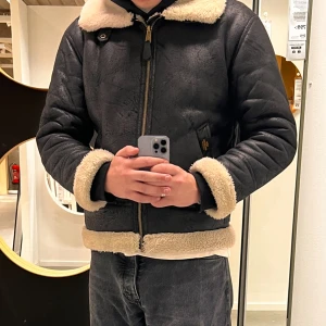 Alpha Industries –  jacka i konstläder (strl L)  - Säkjer en snygg  och varm herrjacka från Alpha Industries i. Varsamt använd och i fint skick,  perfekt för höst och vinter!  • Storlek: L • Modell: Aviator / shearling-inspirerad • Material: Konstläder med mjukt och varmt foder • Passform: Normal • Nypris: ca 2500 kr