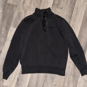 Svart Sail Racing half zip tröja XS - Svart långärmad tröja från Sail Racing i storlek XS. Tröjan har en hög krage med half zip-dragkedja och diskret logga på bröstet. Tillverkad i mjuk bomull med insida i fleece för extra komfort. Perfekt för dig som gillar stilren och sportig look. Passar XS-S och en kortare m på typ 176-178