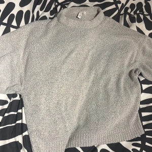 Grå polotröja från NELLY.COM XS - Mysig grå polotröja från NELLY.COM i storlek XS. Tröjan har en hög krage och är stickad med en mjuk struktur. Perfekt för att hålla sig varm under kyliga dagar. Enkel och stilren design som funkar till många olika outfits.