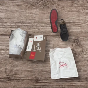 Svarta sneakers från Christian Louboutin - Snygga mörk gråa sneakers från Christian Louboutin med klassisk röd sula. Skick 8/10 nästan nya
