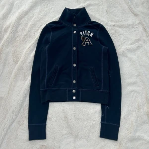 Abercrombie & fitch vintage knapp kofta  - En kofta från Abercrombie & fitch i storlek M. Kan upplevas mindre i storlek, likt en S. Finns fläckar på ärm (se bild). Jag fraktar inom 24h. Se liknande plagg i min profil! 