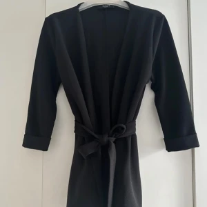 Svart cardigan jacka från Sisters Point - Stilren svart kofta från Sisters Point med knytskärp i midjan. Stilren och enkel design, perfekt för dig som gillar en clean och enkel look