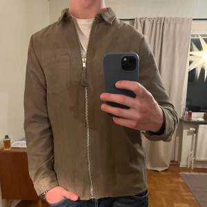 Brun Overshirt med dragkedja  - Säljer denna sjukt snygga Overshirten från Wood Bird⭐️ Färgen är brun och storleken är L✅ Den har inga defekter och skicket är utomordentligt🙌🤝 Sjukt najs passform och passar perfekt till hösten🍁🙌 Tveka inte på att höra av er dig vid minsta fråga eller fundering😊