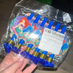 6 st Disney Ariel Födelsedagsfest Tillbehör - 6 st Disney Mermaid Princess Ariel födelsedagsfest tillbehör. Papperstallrikar, muggar, bordsduk, ballonger, baby shower tillbehör. Produkten på bilden är ett set med festblåsare med sjöjungfru-tema, förpackade i plast. De har blå munstycken och färgglada motiv, perfekta för barnkalas eller temafester. Produkten är ny och oöppnad, utan synliga defekter eller slitage.