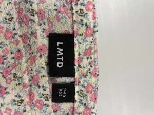 Blommig topp med puffärm från LMTD - Supersöt topp från LMTD med blommigt mönster i rosa. Modellen har korta puffärmar och smockad midja