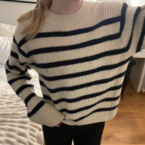 Randig stickad tröja från H&M - Supermysig stickad tröja från H&M i storlek S. Tröjan är ribbad och har mörkblå ränder på en beige bakgrund. Passar M/L (större i storleken). Supermjuk och bra skick! 