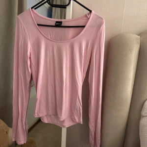 Ljusrosa långärmad topp från Gina Tricot - Säljer en ljusrosa långärmad topp från Gina Tricot, den har slits vid armarna💞