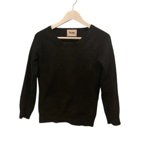 Svart angoratröja från Acne, S - Svart stickad tröja från Acne i storlek S, tillverkad av 70% angora och 30% nylon. Tröjan har rund hals och lång ärm, med en klassisk och clean look som funkar till många olika stilar. Perfekt för dig som gillar minimalistiskt och mjukt material. Bra skick, något liten i storleken.