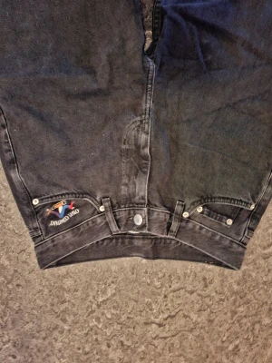 Svarta jeans från Crew Company - Crew Company svarta jeans med rak passform och klassisk femficksdesign. Jeansen har broderad logga i färg vid ena fickan och en patch bak på linningen. Materialet är robust denim och byxorna har normal midja. Perfekt för dig som gillar stilrena och tidlösa jeans.